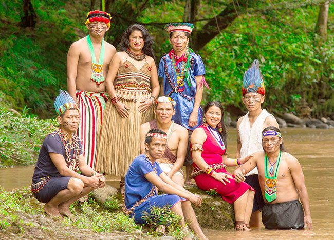 Group of people in traditional Polynesian attire posing outdoors.